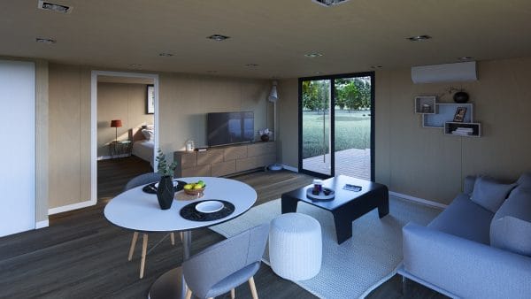 Intérieur moderne et lumineux d'un module en bois avec salon et espace repas intégrés, baie vitrée donnant sur une terrasse en bois et vue sur la nature.