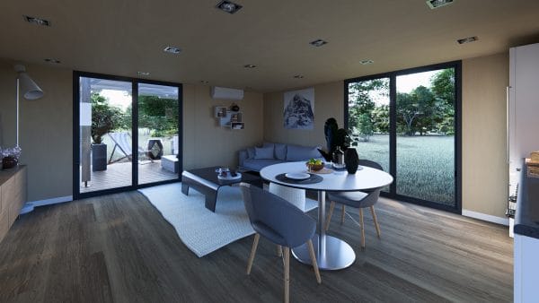 Intérieur moderne d'un module en bois avec espace salon-salle à manger lumineux, grandes baies vitrées donnant sur une terrasse en bois et un jardin verdoyant.