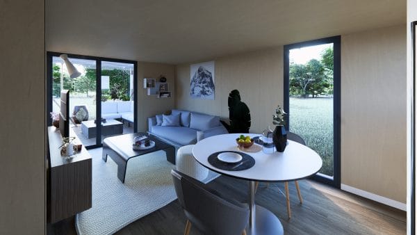 Intérieur lumineux d'un module en bois avec salon et espace repas, grandes baies vitrées donnant sur la terrasse et le jardin