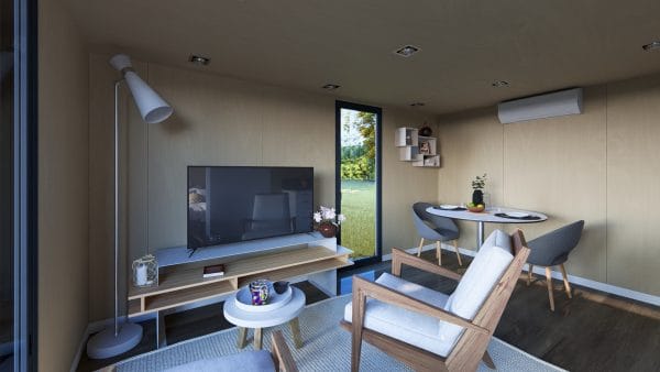 Intérieur moderne et lumineux d'un module en bois avec salon et coin repas, doté d'une grande baie vitrée donnant sur un espace vert.