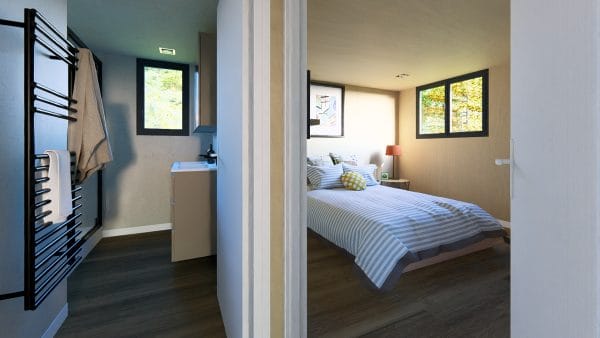 Intérieur moderne d'un module en bois avec vue sur une chambre et sa salle de bain attenante, fenêtres donnant sur la nature