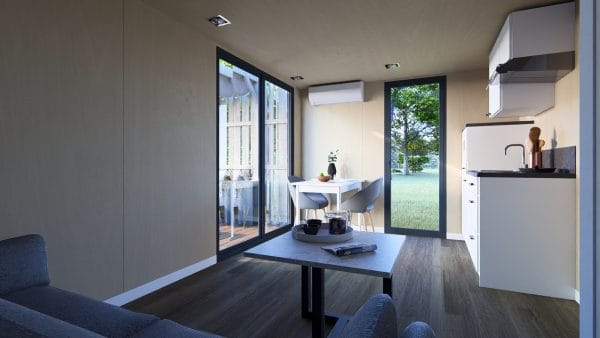 Intérieur lumineux d'un module en bois moderne avec vue sur l'extérieur à travers de grandes baies vitrées.