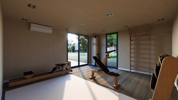 Salle de sport lumineuse et moderne aménagée dans un module en bois, équipée d’appareils de fitness en bois et ouverte sur un jardin grâce à de grandes baies vitrées.